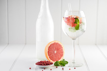 gin and tonic alcohol drink cocktail glass ice fruit garnish plain black white background