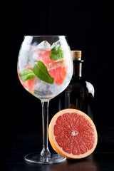 gin and tonic alcohol drink cocktail glass ice fruit garnish plain black white background