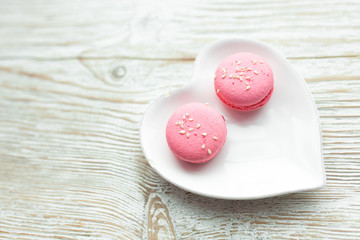 Delicious fresh macaroons on the plate is heart-shaped, lovers
