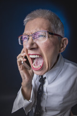Furious senior business woman yelling at her cell phone