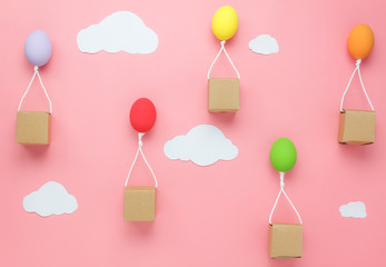 Top view shot of arrangement decoration Happy Easter holiday background concept.Flat lay colorful Easter egg balloon flying transfer gift box on sky pink paper with cloud at office desk.pastel tone.