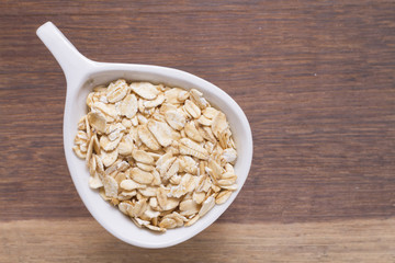 oat flakes in white bowl on wooden table