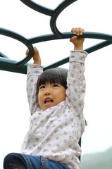 Obraz premium 公園の遊具で遊ぶ女の子