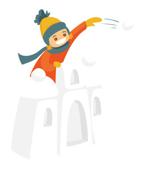 Little caucasian white boy in winter clothes having fun in snow castle and playing snowball fight