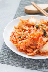 Kimchi cabbage. Korean appetizer on white plate, vertical