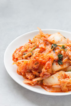 Kimchi cabbage. Korean appetizer on white plate, vertical, copy space