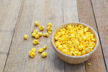 Popcorn cheese salty taste color yellow on wood blow on wooden table with copy space.
