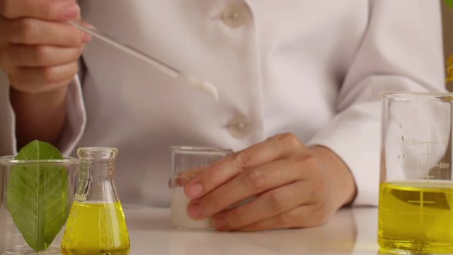 the scientist,dermatologist testing the organic natural cosmetic product in the laboratory.research and development beauty skincare concept.blank package,bottle,container .cream,serum.