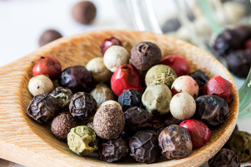 Close up mixed type of the peppercorns in wooden spoon