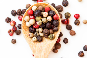 Close up mixed type of the peppercorns in wooden spoon , top view or overhead shot