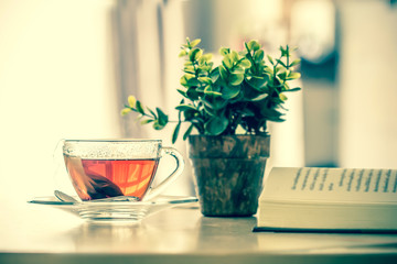 Close up the warm black tea cup on the wooden table in living room , relax with tea time concept