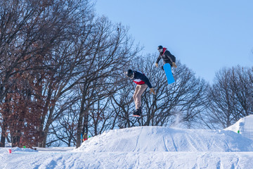 People are having fun in downhill skiing and snowboarding