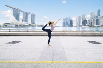 Fototapeta na wymiar Young woman exercising yoga at outdoor
