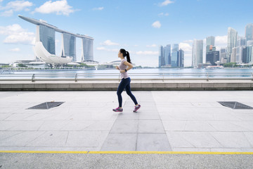 Asian woman jogging on the esplanade bridge