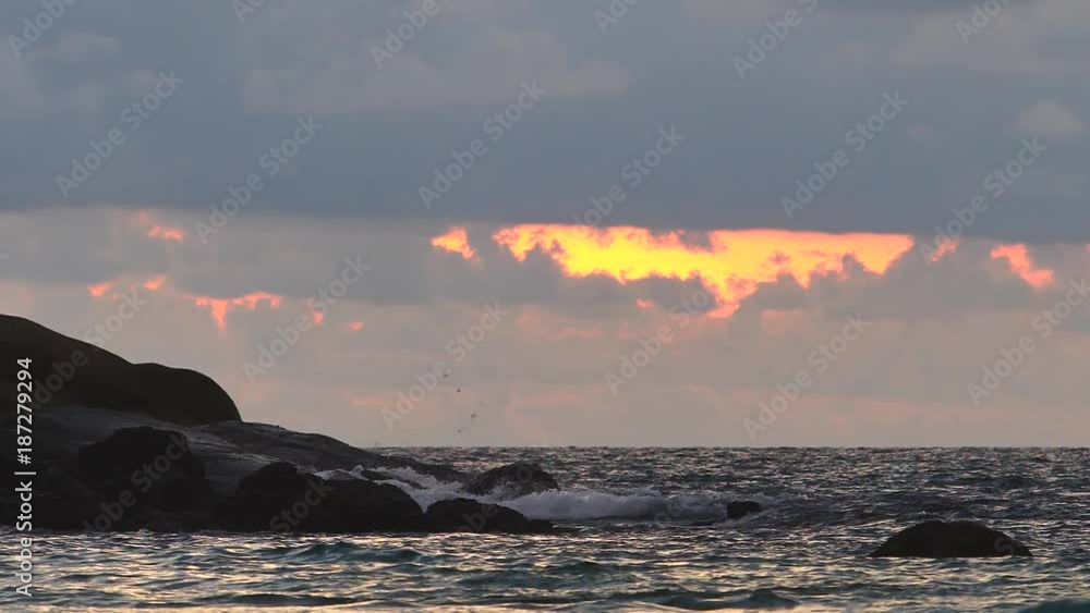 Wall mural sea shallow water incoming waves with foam and splashes in slow motion on sunset background