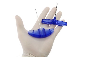 Three parts of bone marrow biopsy needle held in palm of doctor left hand in powdered latex glove,...
