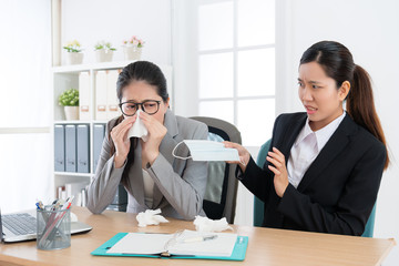 female office worker catches cold blowing nose