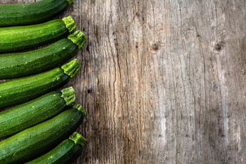 Ripe zucchini, green vegetables, organic farm fresh produce on wooden background