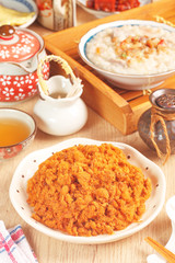 Dried shredded pork (or pork floss) with tea and gruel  on wooden table     