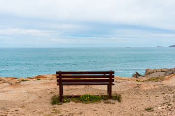 Naklejka na ściany i meble Empty bench with picturesque view towards the open ocean, sea