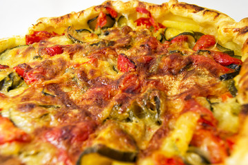 vegetables salad pie. quiche with zucchini, peppers, potatoes and puff pastry. for vegerarian cousine concept