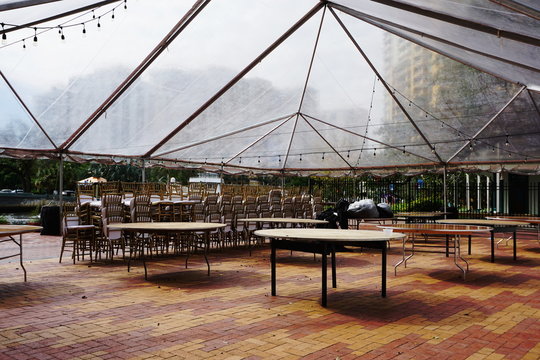 Clear Tent Event Setup with Stacked Chairs in Urban Setting