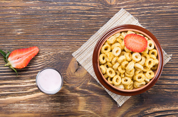 breakfast cereal and a glass of yogurt on a wooden board