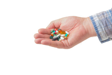 Pile of different tablets and capsules in man's hand closeup