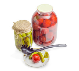 Two different jars and saucer with canned cucumbers and tomatoes