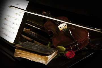 Antic violin with book rose and note