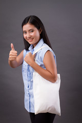 happy woman holding recycle bag, giving thumb up gesture