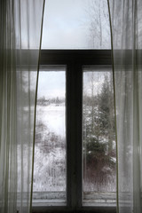 Window of old abandoned farm house in Southern Finland. Cold winter day.