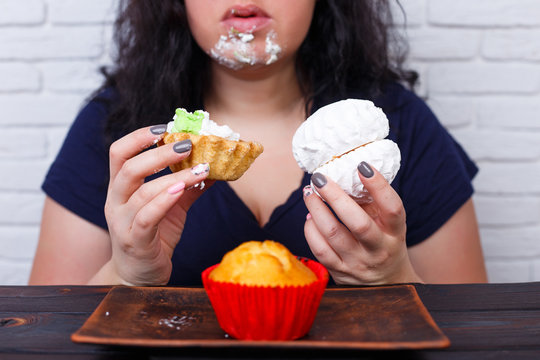 Food Addiction, Dieting Concept. Young Overweight Woman Fed Up With Diets Eating A Cake Greedily, Staining  Face In Cream.