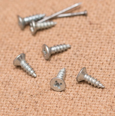 nails and screws on a wooden background