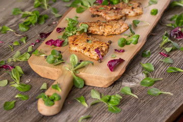 Fresh freshly fried delicious slices of meat on a wooden board with fresh herbs. Appetizing steaks on a wooden board. Still life.