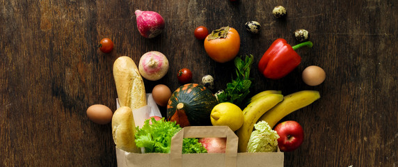Top view paper bag different health food wooden background