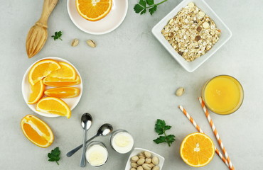 healthy breakfast of freshly squeezed orange juice, oatmeals and pistachio nuts on a light gray table. top view