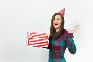 Beautiful smiling caucasian fun young happy woman in plaid dress and birthday party hat with two gift present boxes, celebrating and enjoying holiday on white background isolated for advertisement.