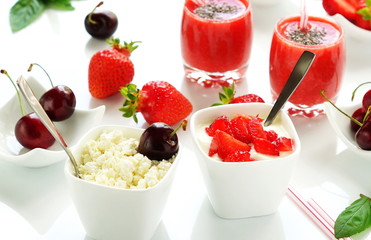 tasty and healthy smoothies made from fresh strawberries and chia seeds in glasses, yogurt with strawberries and curd on white background table