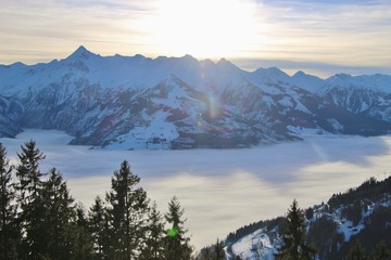 View of the mountain range Glockner group with mountain Kitzsteinhorn (3200 m) in the region Zell am See - Kaprun, in winter. Dense fog over the valley. National Park Hohe Tauern, Austria, Europe.