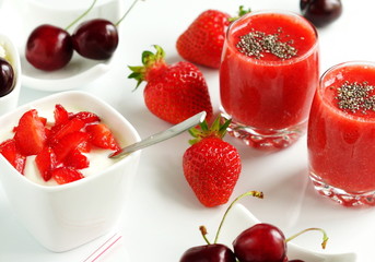 tasty and healthy smoothies made from fresh strawberries and chia seeds in glasses, yogurt with strawberries and curd on white background table