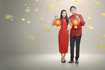 Happy chinese couple in cheongsam clothes holding red lanterns - Powered by Adobe