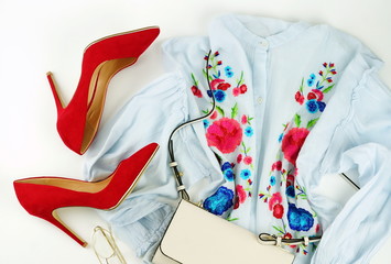 flat lay feminine clothes and accessories collage with blouse with embroidery, red high heel shoes...