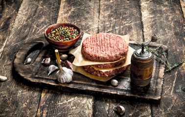 Raw burger with spices and herbs.