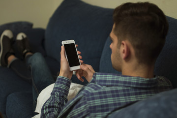 young man on the couch with the mobile phone