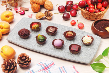 Chocolate candies of different shapes on gray slate plate 