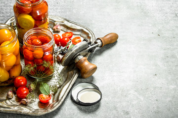 Pickled tomatoes with spices and seamer.