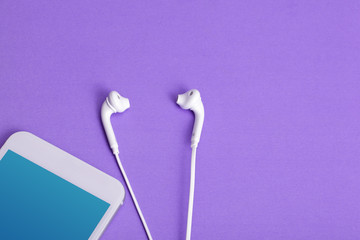Mobile phone with earphone on purple background