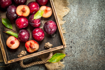 Ripe plums with a wooden box.