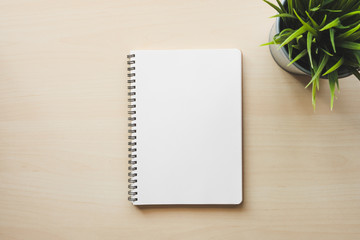 Empty white notebook top view on wooden table
